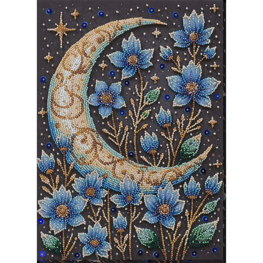 Decorative panel with a beaded design of a crescent moon and blue flowers on a dark background.