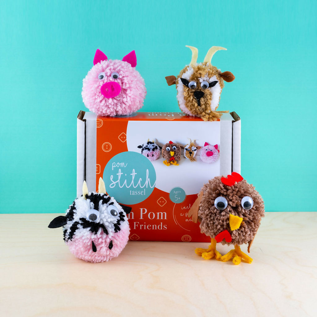 Four pom-pom animals in front of a 'Pom Stitch' box on a light blue background