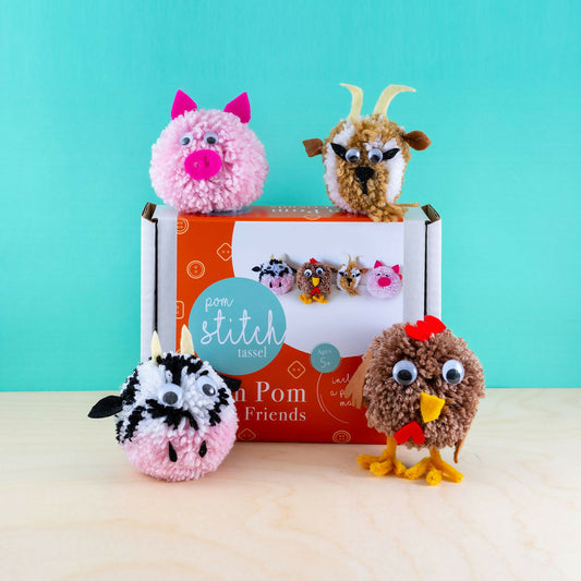 Four pom-pom animals in front of a 'Pom Stitch' box on a light blue background
