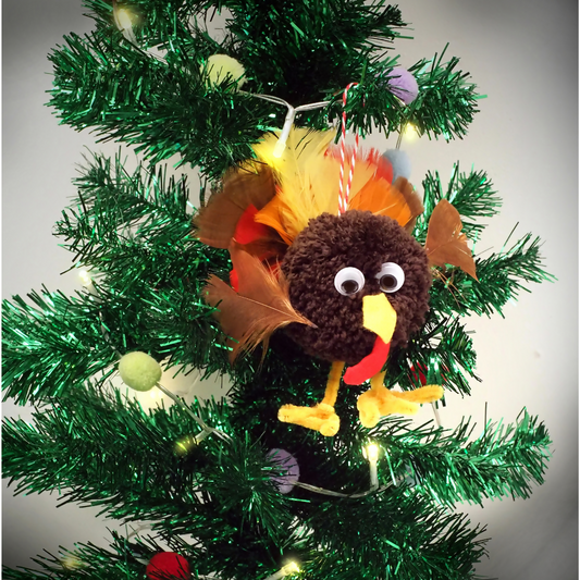 Plush turkey ornament on a decorated Christmas tree with lights and tinsel.